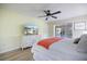 Spacious main bedroom with wood floors and slider access to the screened-in lanai and a large dresser with a TV at 9277 Saint Catherine Ave, Englewood, FL 34224