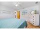 Main bedroom with a light color scheme, wood floors, dresser, and a view to the house at 9277 Saint Catherine Ave, Englewood, FL 34224