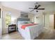 Bright main bedroom features wood floors, a ceiling fan, serene décor, and lots of natural light from two windows at 9277 Saint Catherine Ave, Englewood, FL 34224