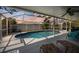 Inviting screened-in pool area with relaxing lounge chairs and string lights for evening enjoyment at 9277 Saint Catherine Ave, Englewood, FL 34224