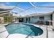 Inviting screened-in pool area with lounge chairs, dining set, ceiling fan, and a clear blue swimming pool at 9277 Saint Catherine Ave, Englewood, FL 34224