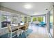 Bright sunroom with tiled floor and outdoor views, complemented by casual seating and a dining area at 9277 Saint Catherine Ave, Englewood, FL 34224