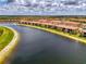 Expansive aerial view showcases the waterfront condos nestled along a serene lake, reflecting clear skies at 10213 Staggerbush Dr # 202, Venice, FL 34293