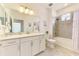 A bright bathroom with a vanity, shower-tub combo, and stylish coastal-themed decorations at 10213 Staggerbush Dr # 202, Venice, FL 34293