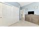 Spare bedroom with a large sliding door closet, TV, and calming blue walls at 10213 Staggerbush Dr # 202, Venice, FL 34293