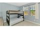 A cozy bedroom featuring a twin bunk bed, large windows, and a calming blue color scheme at 10213 Staggerbush Dr # 202, Venice, FL 34293