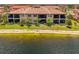 Lovely exterior view of the property near the lake, with a patio and balcony on each level at 10213 Staggerbush Dr # 202, Venice, FL 34293