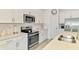 Stylish kitchen with stainless steel appliances, white cabinetry, subway tile backsplash, and quartz countertops at 10213 Staggerbush Dr # 202, Venice, FL 34293