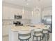 Bright, white kitchen with stainless steel appliances and a large center island with bar stool seating at 10213 Staggerbush Dr # 202, Venice, FL 34293