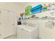 Functional laundry room with washer, dryer, and ample storage space on wire shelving at 10213 Staggerbush Dr # 202, Venice, FL 34293