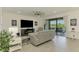 Spacious living room with comfortable seating, entertainment center, and sliding glass doors leading to an outdoor balcony at 10213 Staggerbush Dr # 202, Venice, FL 34293