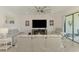 Bright living room with modern furnishings, a large television, and access to an outdoor balcony, perfect for relaxing at 10213 Staggerbush Dr # 202, Venice, FL 34293