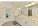 A luxurious main bathroom with double sinks, a large mirror, and a separate shower at 10213 Staggerbush Dr # 202, Venice, FL 34293
