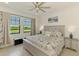 A beautifully appointed main bedroom featuring a ceiling fan and scenic views from the bright window at 10213 Staggerbush Dr # 202, Venice, FL 34293