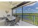 Enjoy the lake view from this screened lanai with ceiling fan and outdoor dining set at 10213 Staggerbush Dr # 202, Venice, FL 34293