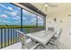 Enjoy water views from this cozy screened lanai, complete with dining set and ceiling fan at 10213 Staggerbush Dr # 202, Venice, FL 34293