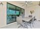 Outdoor patio featuring a dining table set with view through sliding glass doors at 10213 Staggerbush Dr # 202, Venice, FL 34293