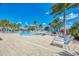 Resort-style pool features comfortable lounge chairs for sunbathing on a spacious deck, all surrounded by palm trees at 10213 Staggerbush Dr # 202, Venice, FL 34293