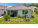 Landscaped backyard with a covered patio, lush grass, and tropical plants at 10367 Abaco Falls Dr, Englewood, FL 34223