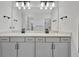 Bathroom featuring double vanity with white countertops, modern lighting, and sleek fixtures at 10367 Abaco Falls Dr, Englewood, FL 34223