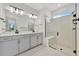 Bright bathroom featuring double vanity with white countertops and a spacious glass-enclosed shower with a built-in bench at 10367 Abaco Falls Dr, Englewood, FL 34223