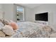 Bright bedroom featuring a decorative paisley bedspread, complementing pillows, a large window, and tv at 10367 Abaco Falls Dr, Englewood, FL 34223