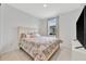 Bright bedroom featuring a decorative paisley bedspread, complementing pillows, and a large window at 10367 Abaco Falls Dr, Englewood, FL 34223