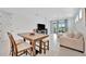 Dining room with natural wood table that flows into the living room with comfortable furniture at 10367 Abaco Falls Dr, Englewood, FL 34223