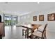 Stylish dining area with wooden table and chairs, opening to a living room with lots of sunlight at 10367 Abaco Falls Dr, Englewood, FL 34223