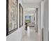 Hallway view leading to a bright, open-concept living and dining area with neutral decor and natural light at 10367 Abaco Falls Dr, Englewood, FL 34223