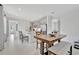 Open-concept kitchen and dining area with gray cabinets, an island with seating, and a wooden dining table at 10367 Abaco Falls Dr, Englewood, FL 34223