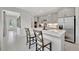 Modern kitchen with gray cabinets, stainless steel appliances, a center island, and herringbone backsplash and adjoining hallway at 10367 Abaco Falls Dr, Englewood, FL 34223