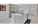 A bright kitchen island with a sink, dishwasher, and dark pulls sits in a well lit area with a view of the yard at 10367 Abaco Falls Dr, Englewood, FL 34223