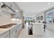 Bright, modern kitchen with gray cabinets, stainless steel appliances, an island, and a herringbone backsplash at 10367 Abaco Falls Dr, Englewood, FL 34223
