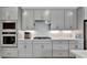 Modern kitchen featuring gray cabinets, stainless steel appliances, and quartz countertops at 10367 Abaco Falls Dr, Englewood, FL 34223