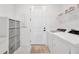 Bright laundry room with white washer and dryer, storage shelves, and convenient utility sink at 10367 Abaco Falls Dr, Englewood, FL 34223