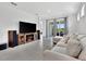 Well-lit living room with tile floors, large TV, comfortable seating and sliding glass doors at 10367 Abaco Falls Dr, Englewood, FL 34223