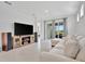 Comfortable living room with tile flooring, large TV, and sliding glass doors to the outdoor patio at 10367 Abaco Falls Dr, Englewood, FL 34223
