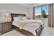 Serene main bedroom with a large window offering scenic views and tray ceiling at 10367 Abaco Falls Dr, Englewood, FL 34223