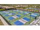 Aerial view of the community's modern pickleball courts surrounded by lush landscaping and neighborhood homes at 10367 Abaco Falls Dr, Englewood, FL 34223