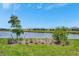 Scenic view of a pond with lush green grass and homes in the distance at 10367 Abaco Falls Dr, Englewood, FL 34223