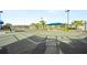 Well-maintained tennis court with pristine green surface, netting, and shade structure on a sunny day at 10367 Abaco Falls Dr, Englewood, FL 34223