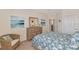 Comfortable bedroom with beach themed decor, dresser, and a cozy wicker chair at 10789 Tarflower Dr # 202, Venice, FL 34293