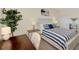 Bright bedroom with a decorative bed, desk, bookshelf and a leafy plant at 10789 Tarflower Dr # 202, Venice, FL 34293