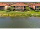 Close-up exterior of a lakeside home featuring well-maintained landscaping and scenic water views at 10789 Tarflower Dr # 202, Venice, FL 34293