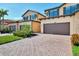 Townhome exterior with brick driveway, lush landscaping, and attached garage at 10789 Tarflower Dr # 202, Venice, FL 34293