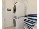 Bright laundry room with stacked washer and dryer, shelving and cheerful decor at 10789 Tarflower Dr # 202, Venice, FL 34293