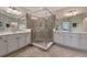 Luxurious bathroom features dual vanities, a spacious glass-enclosed shower, and modern finishes for a spa-like experience at 10789 Tarflower Dr # 202, Venice, FL 34293