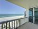 Spacious balcony with direct ocean views of white sands and palm trees through sliding glass doors at 1100 Tarpon Center Dr # 503 5C, Venice, FL 34285