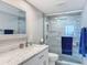 Modern bathroom features marble countertop, framed mirror, sleek glass shower with tiled walls at 1100 Tarpon Center Dr # 503 5C, Venice, FL 34285